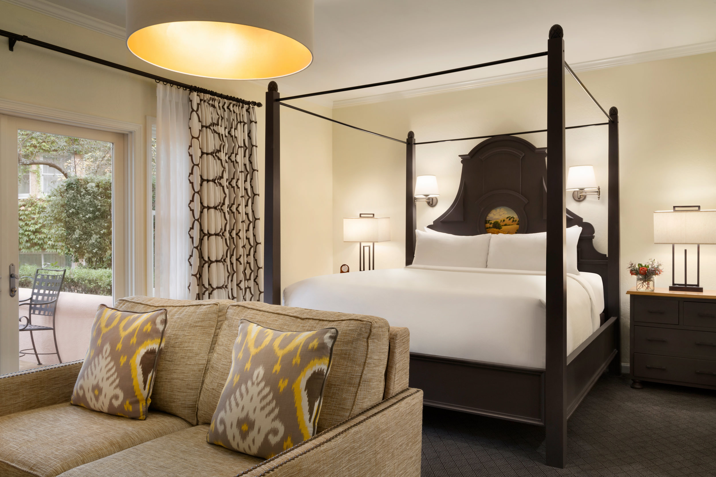 Bedroom with four post bed and small sofa