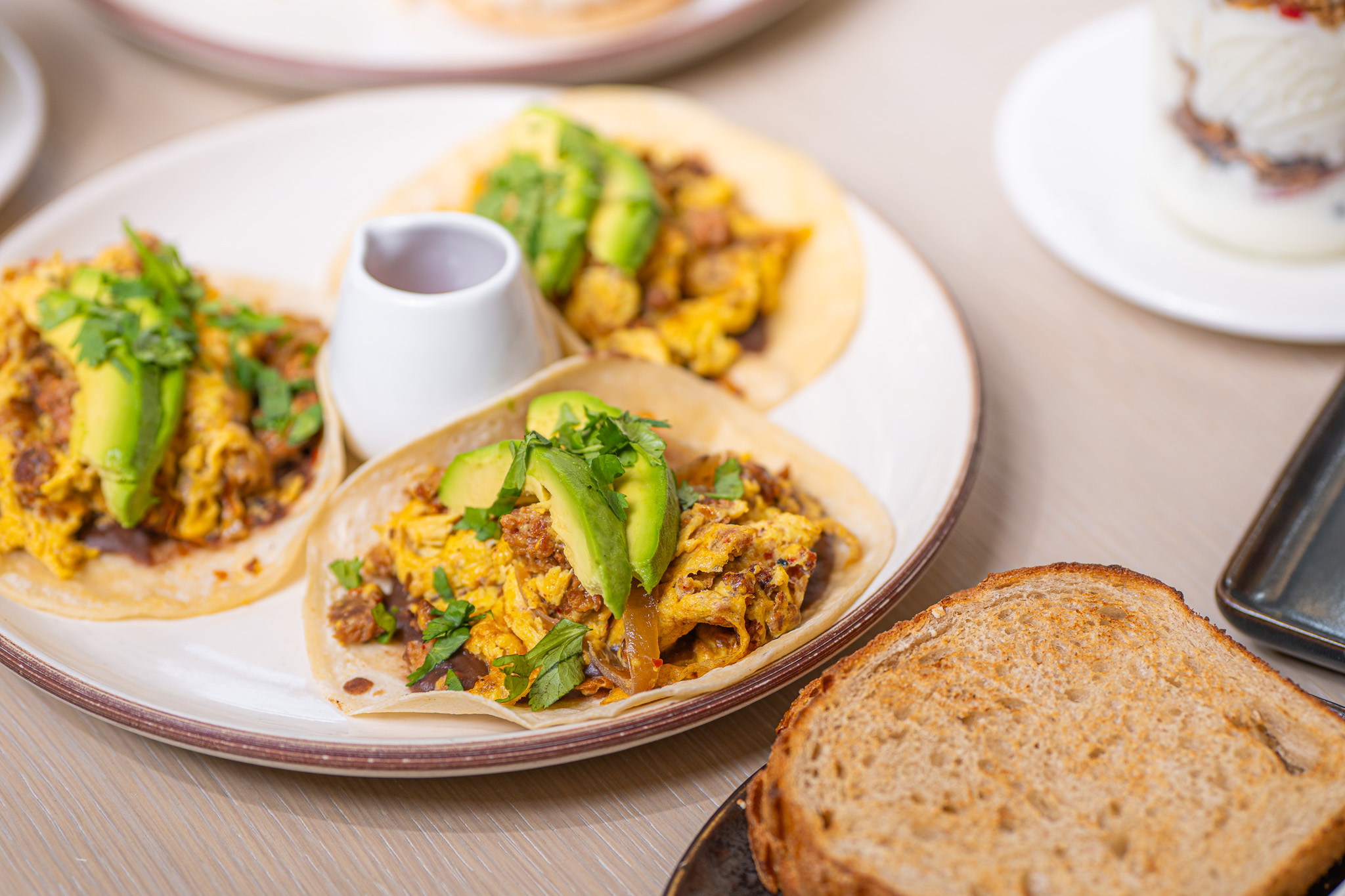 Plate of chorizo tacos topped with sliced avocado at Santé Restaurant