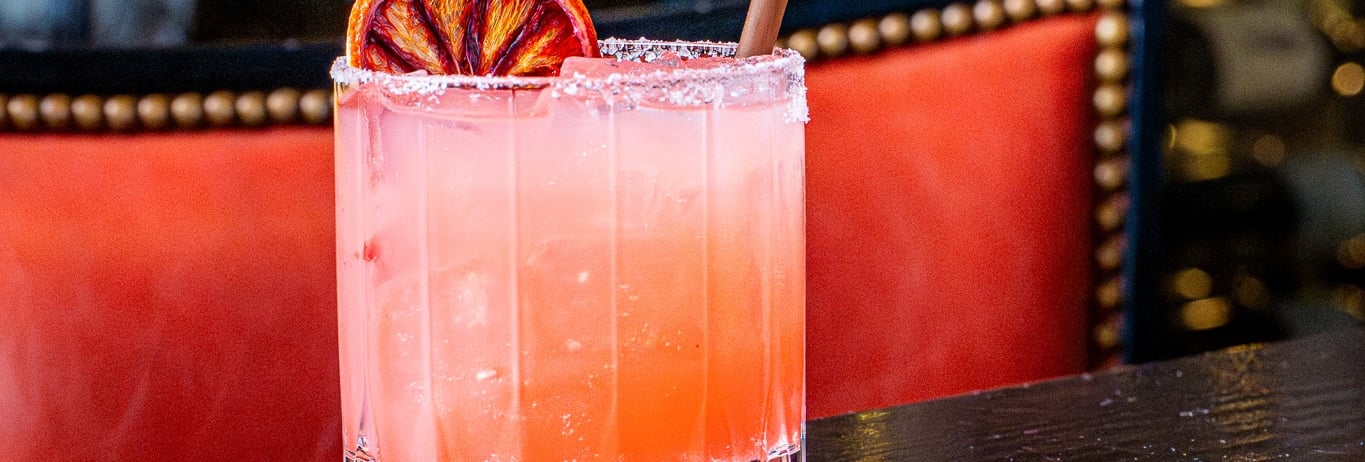 Vibrant colored cocktail with dried fruit garnish