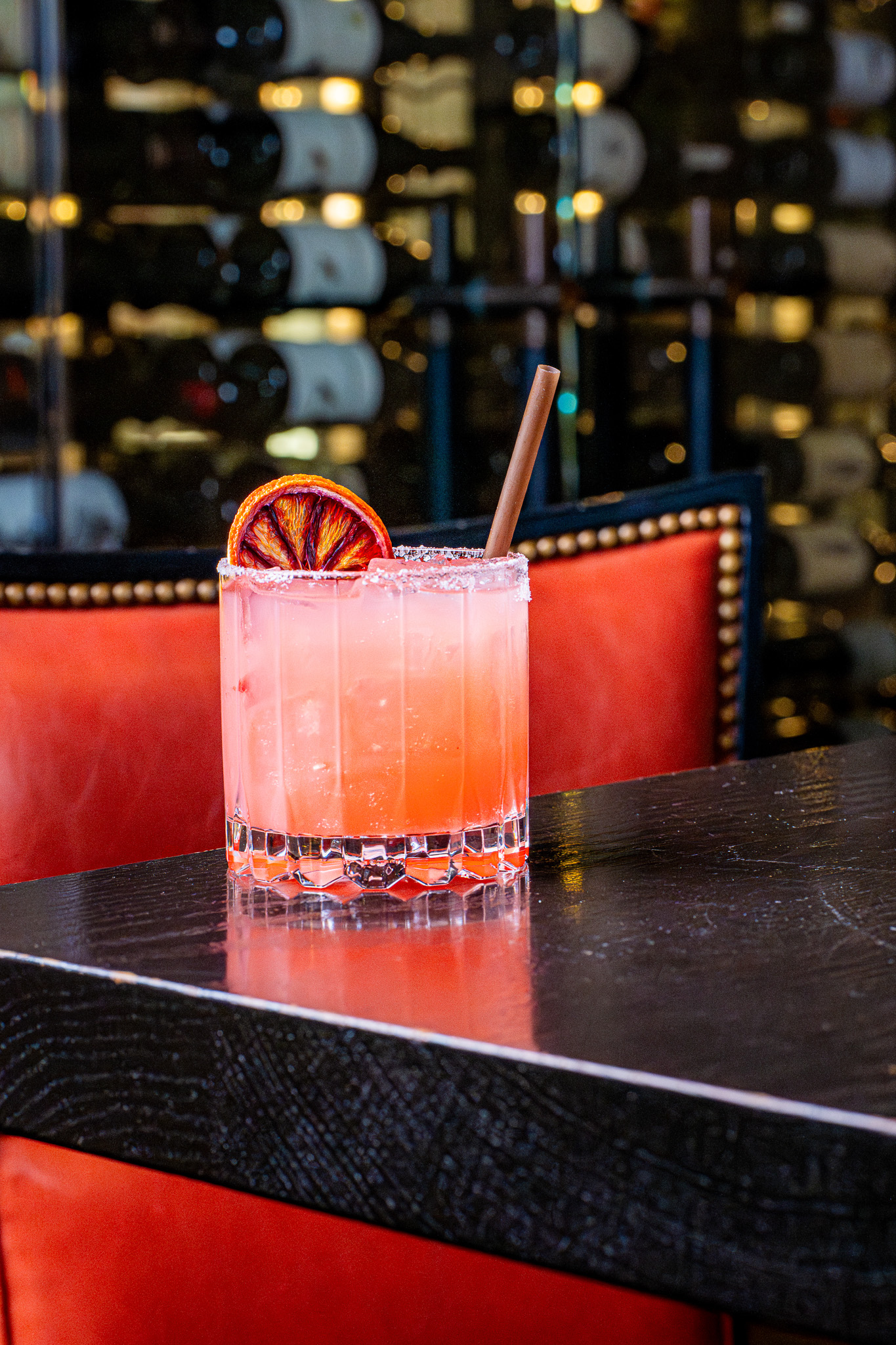 Vibrant colored cocktail with dried fruit garnish