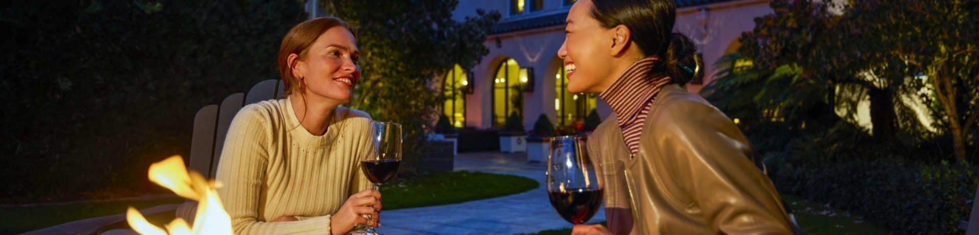two women enjoying wine and a cheese plate while sitting around an outdoor firepit in front of fairmont sonoma