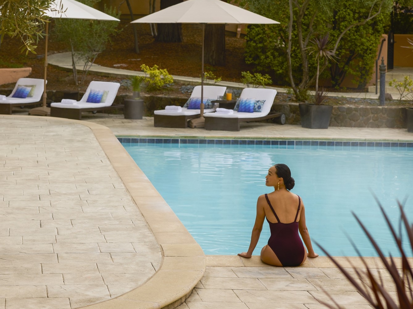 woman sitting on edge of pool