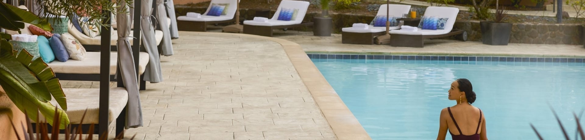 woman sitting on edge of pool