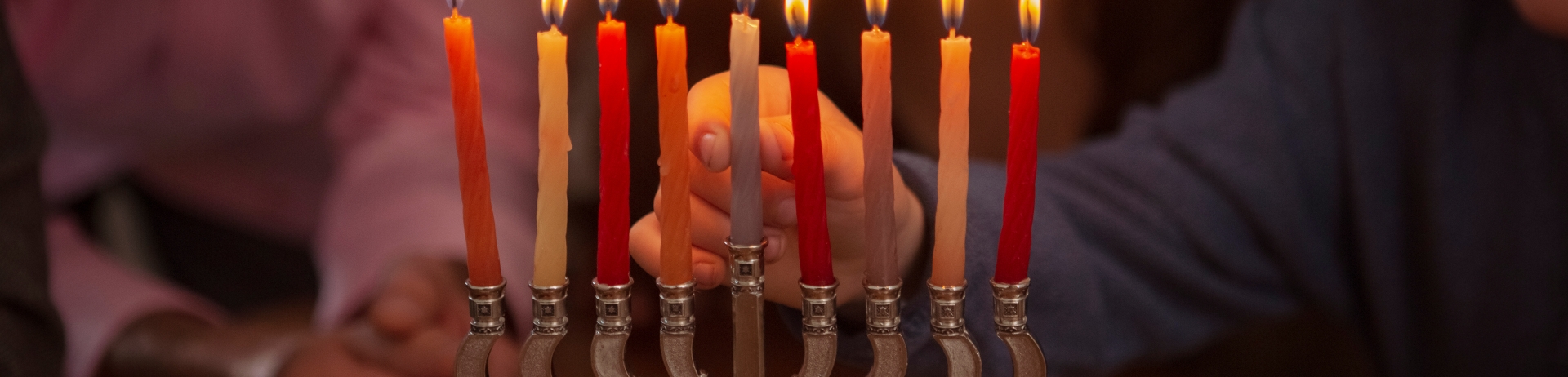 family lighting a Hanukkah menorah