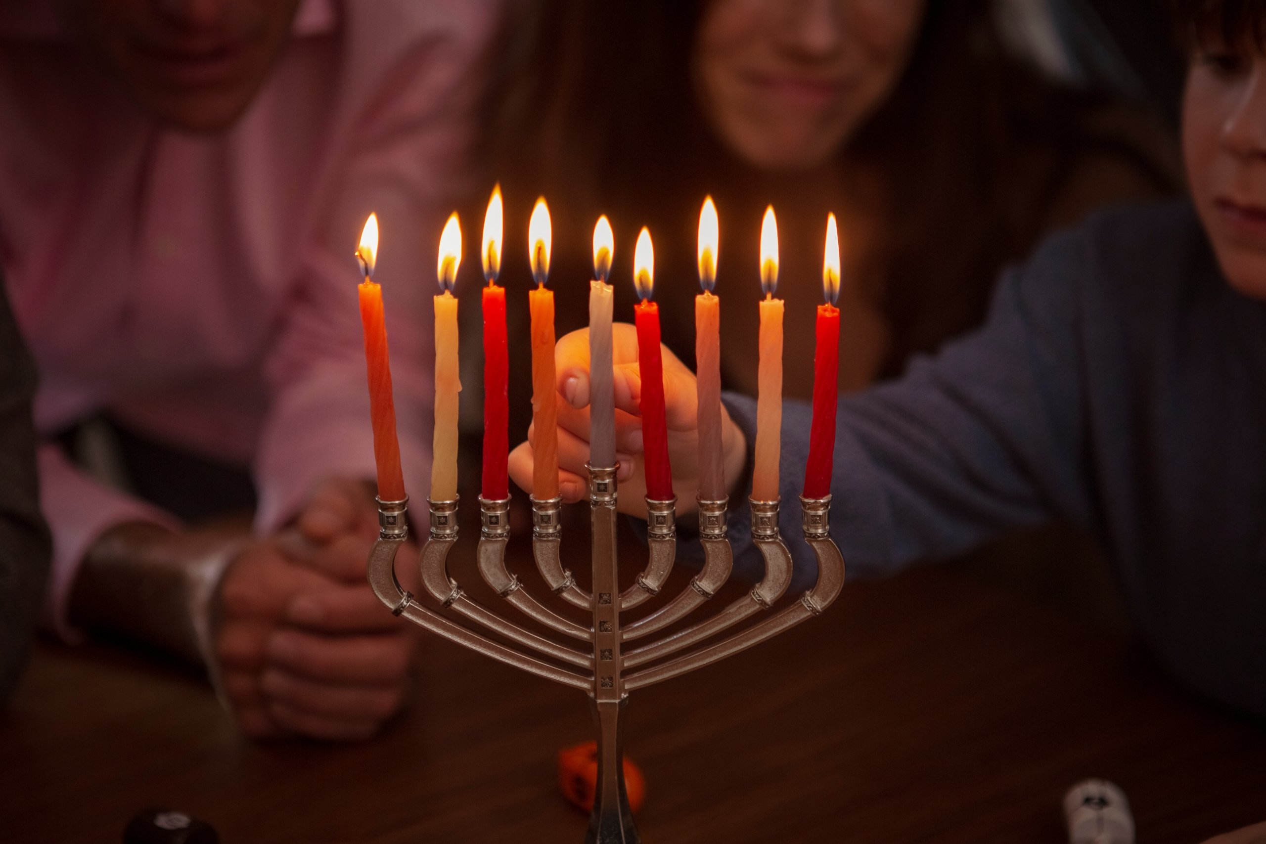 family lighting a Hanukkah menorah