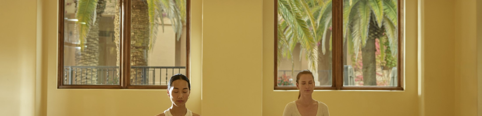 two women doing a yoga post in wellness studio