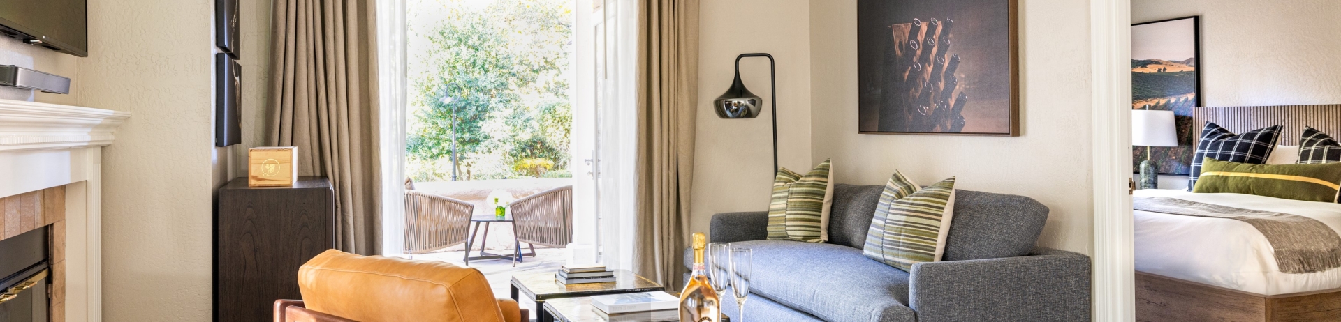 gloria ferrer one bedroom suite with champagne on table and french doors that open to a private patio