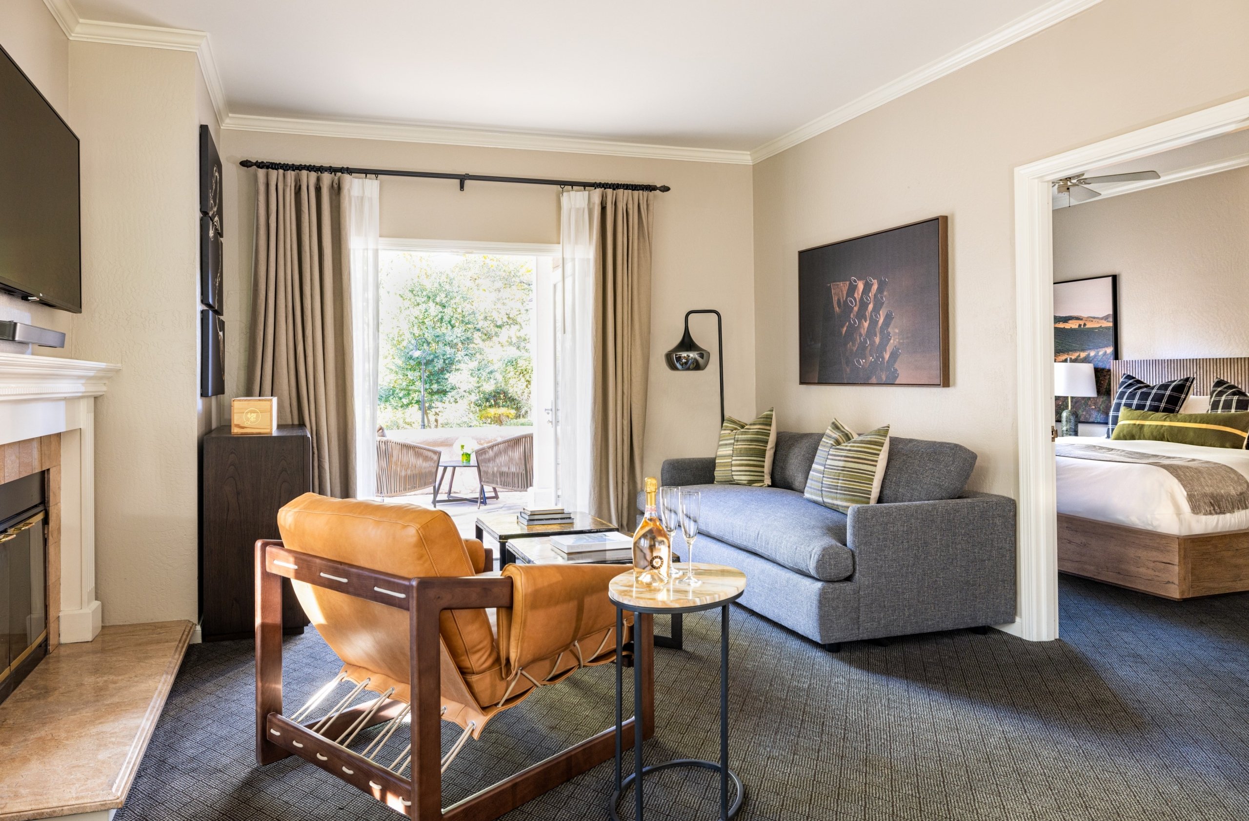 gloria ferrer one bedroom suite with champagne on table and french doors that open to a private patio