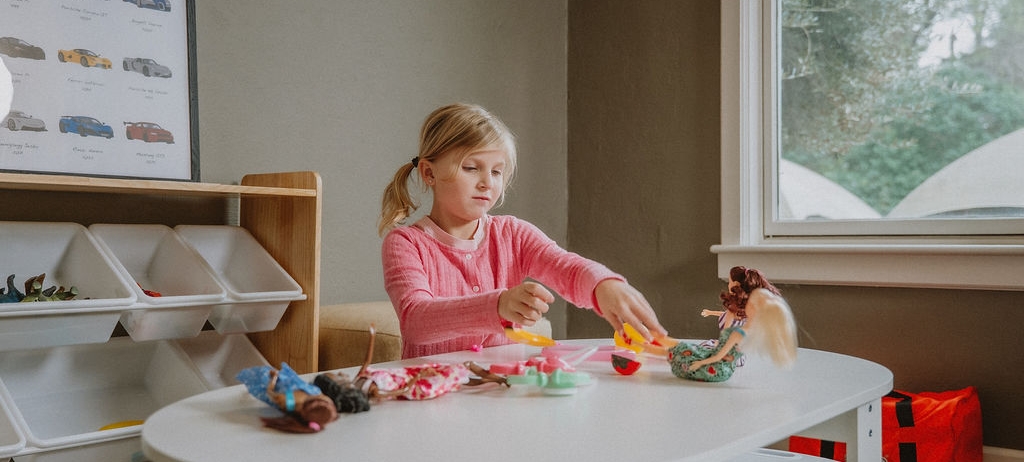 little girl playing with dolls