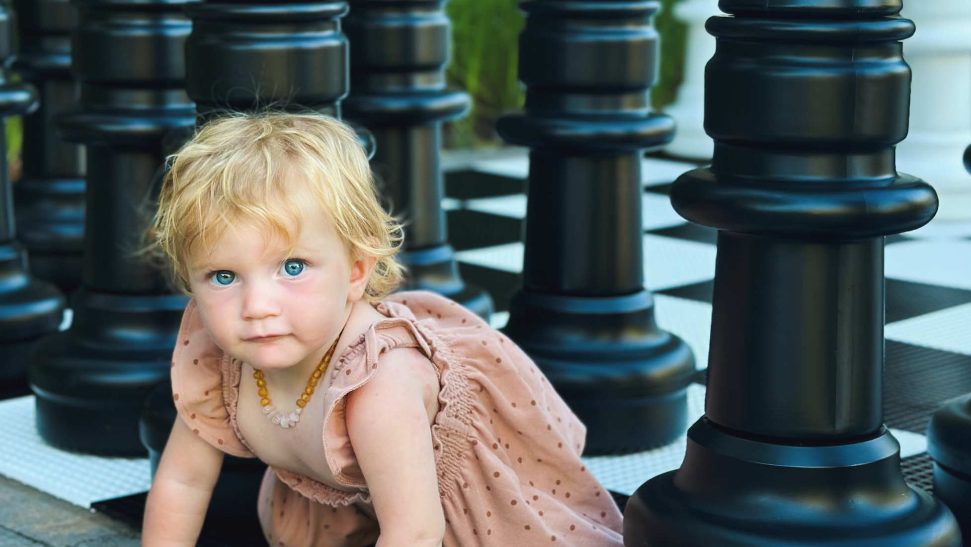 Toddler playing among a set of giant chess. photo by Julia Mancuso