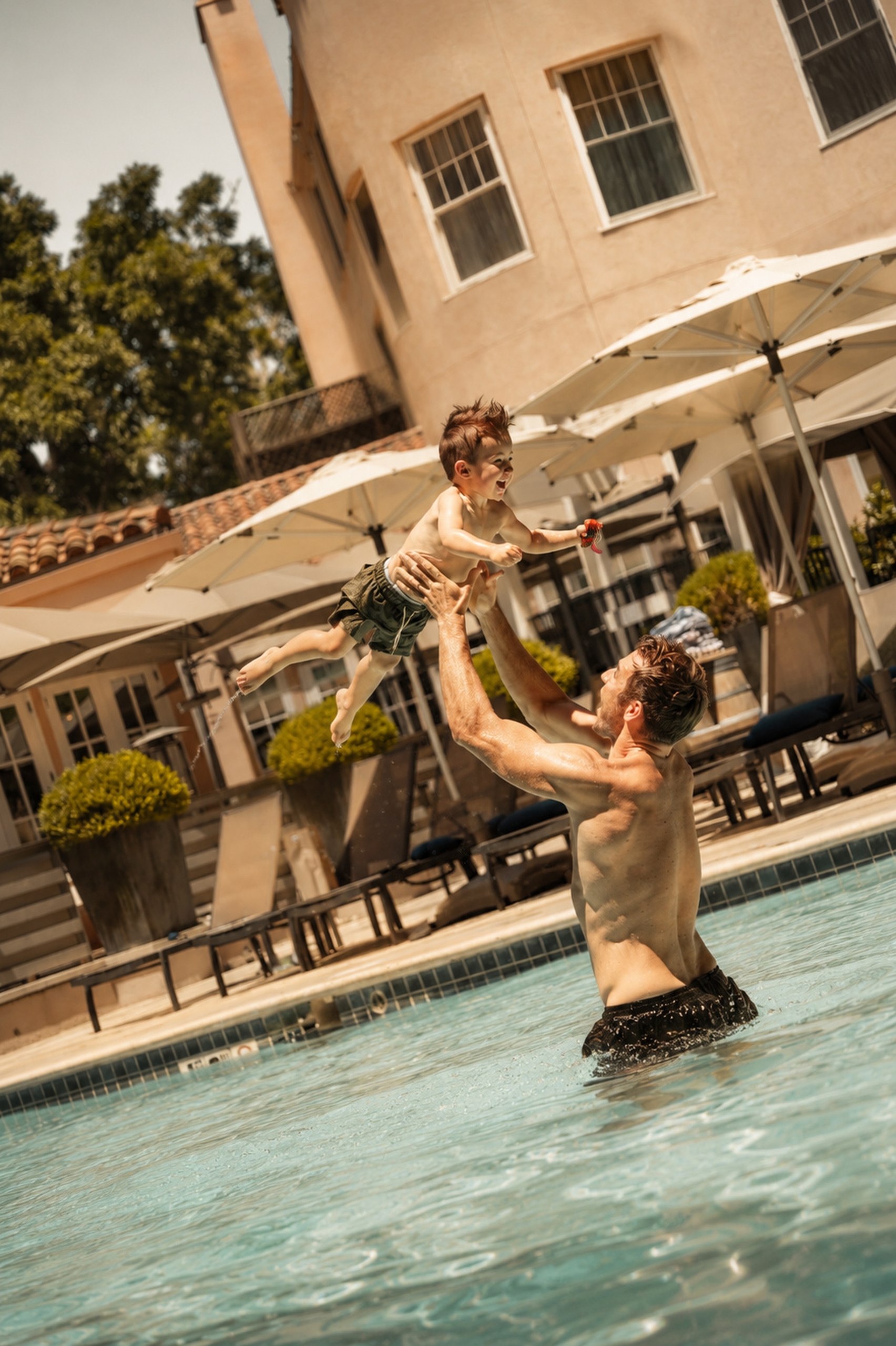 Young boy and father splashing in the pool at fairmont sonoma