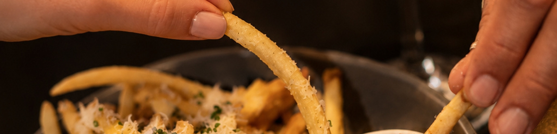 Plate overflowing with truffle fries paired with an ice cold martini