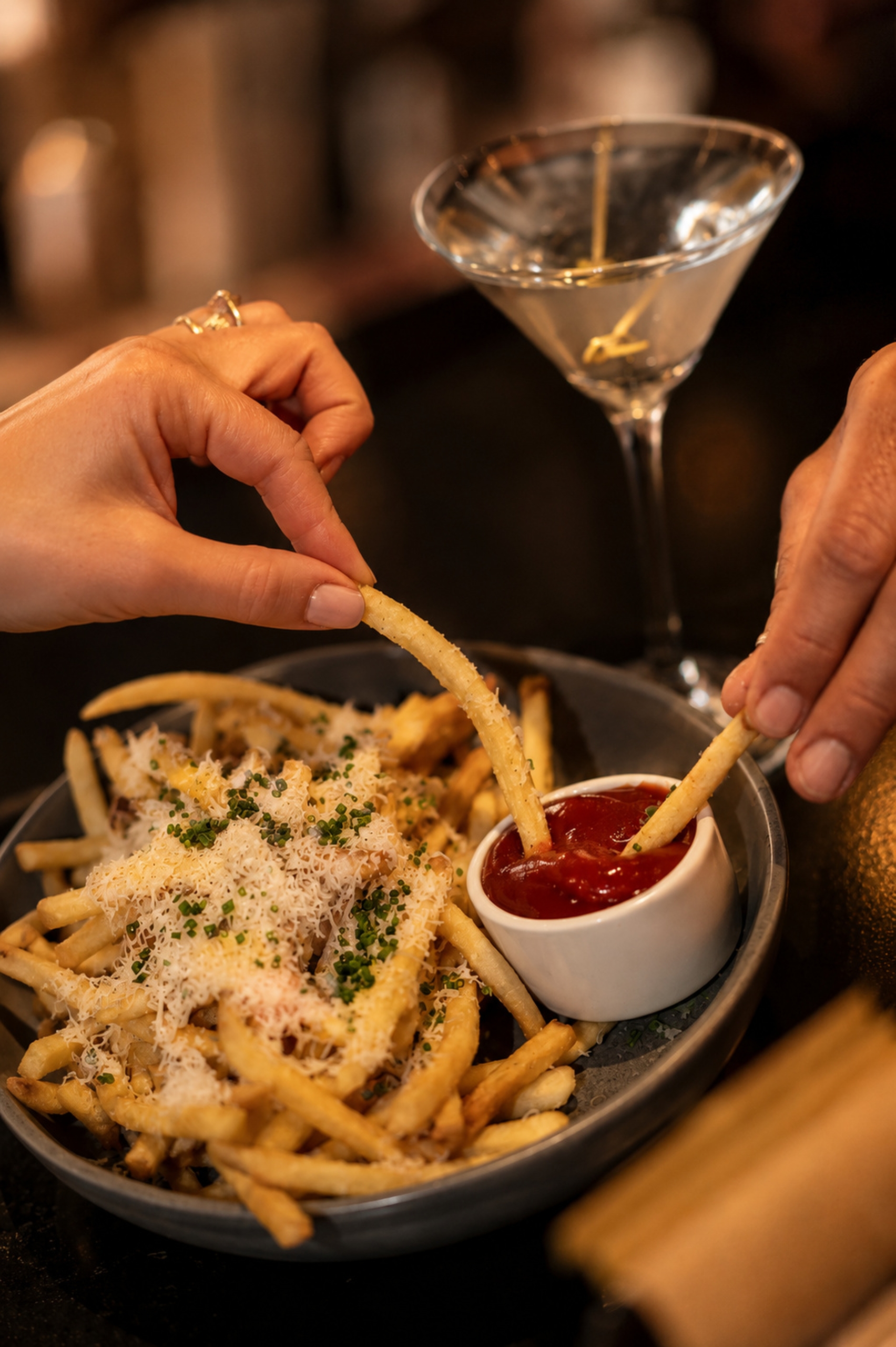 Plate overflowing with truffle fries paired with an ice cold martini